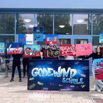 Schüler*innen mit Schildern vor der GodeWind Schule Rostock